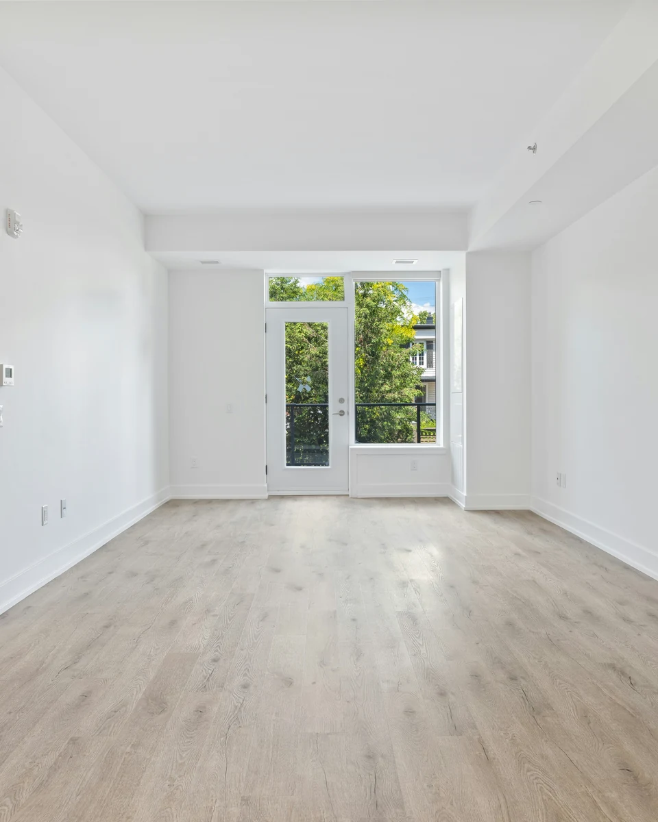 Vacant modern suite with pale oak floors and a balcony window